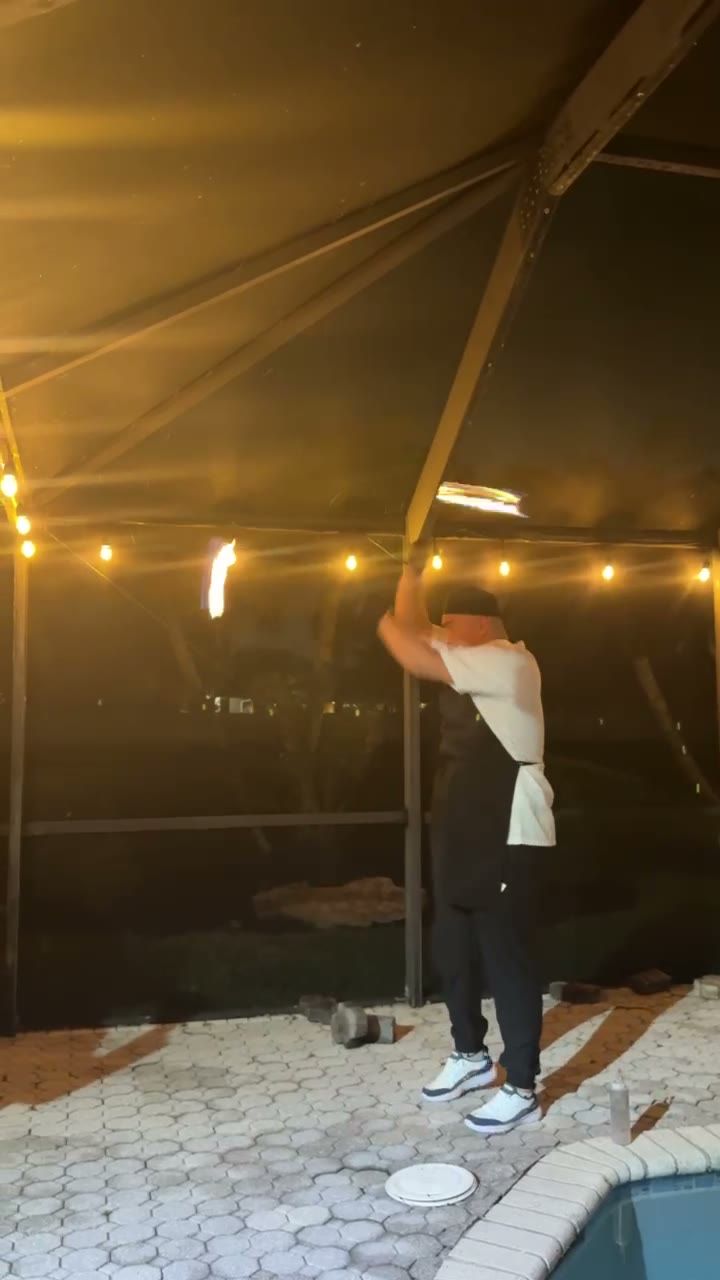 Chef juggling fire torches by the pool